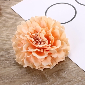 Macro shot of apricot peony hair clip featuring layered silk petals on wood background