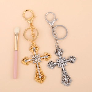 Cross-shaped keychain set in gold and silver with sparkling rhinestones and lobster clasp