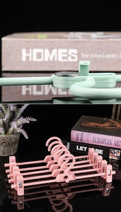 Detail of non-slip plastic pants rack with rotating clips in green and pink finish