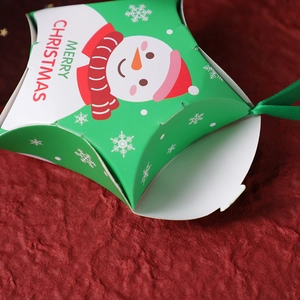 Green star-shaped Christmas gift box with snowman print and ribbon handle