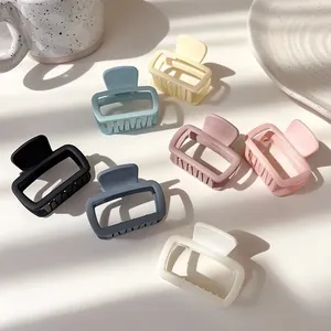 Set of seven matte square hair claws in soft cream and pastel colors on white surface
