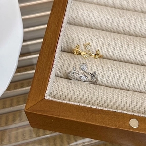 Elegant gold and silver tulip rings with cubic zirconia pavé in a wooden jewelry box