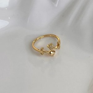 Macro shot of gold tulip ring with micro-pave white zircons on white ceramic base