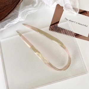 Detail view of U-shaped hair pin with amber and pink gradient acetate finish