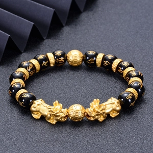 Obsidian bracelet with golden Pixiu and engraved mantra beads on dark textured base