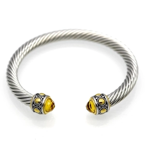 Detail of twisted cable cuff bangle featuring yellow faceted gemstones and silver ends