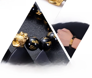 Détails macro des perles d'obsidienne avec mantra doré et breloque Pixiu aux textures fines