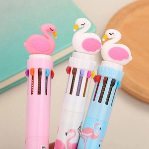 Three multi-color retractable ballpoint pens with pink flamingo toppers on a wooden tray