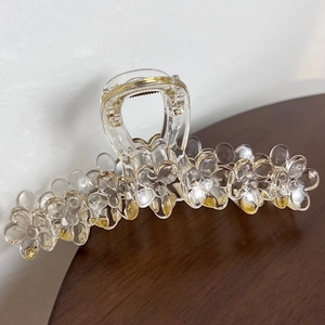 Macro shot of 13cm transparent flower hair claw clip on a natural wooden surface