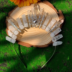 Detail of natural clear quartz crystal crown with sunburst motif on mossy wood base