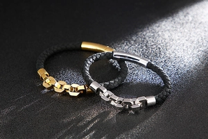 Detailed view of woven leather bracelets with gold and silver chain link buckles