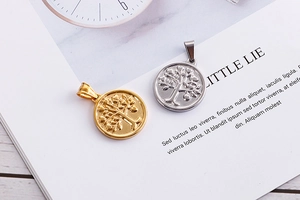 Detail of tree of life pendants in gold and silver finish on a minimalist desk