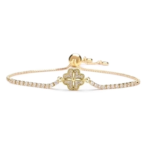Detail of adjustable gold bracelet featuring a clover charm set with sparkling cubic zirconia