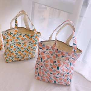 Détail de sacs en coton avec motifs de fruits et étiquette tissée décorative