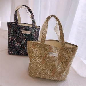 Détail de sacs à main en coton à fleurs avec fermeture éclair et étiquette textile