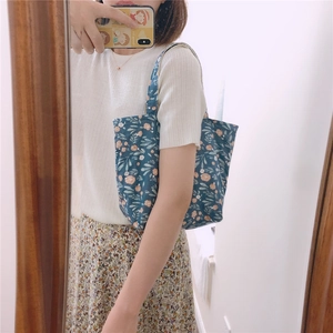 Selfie miroir montrant un sac en toile bleu marine à fleurs roses avec motif floral frais