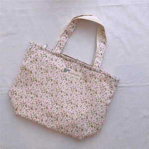 Détail du sac cabas en toile florale avec fleurs roses délicates et fermeture éclair