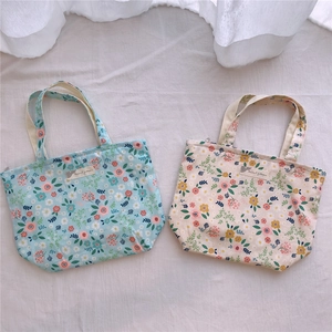 Détails de petits sacs en toile à fleurs avec motifs marguerites en bleu et beige