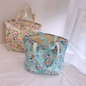 Détail d'un sac cabas en toile florale avec fermeture éclair et étiquette tissée d'animaux
