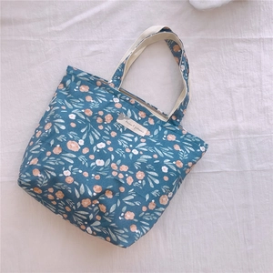 Détail du sac à main en coton à motif floral bleu avec étiquette textile décorative