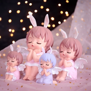 Set of four cute angel girl figurines in pink and purple on soft tulle backdrop