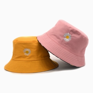 Detailed close-up of daisy embroidery on high-quality yellow and pink cotton bucket hats