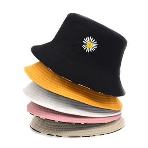 Detail showing five colors of cotton daisy bucket hats with reversible floral patterns