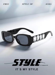 Detail of luxury rectangle sunglasses featuring large crystal embellishments on the temples