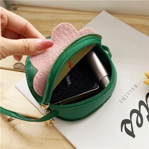 Green strawberry-shaped mini crossbody bag for girls showing storage for cosmetics