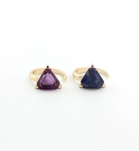 Close-up of triangle-cut amethyst and lapis lazuli gemstones set in gold open rings