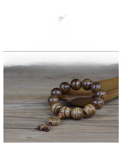 Macro shot of 108 agarwood prayer beads showing natural wood grain and glossy texture