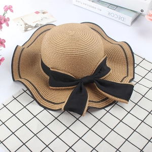 Elegant wide brim straw sun hat with black ribbon bow and wavy edges for women