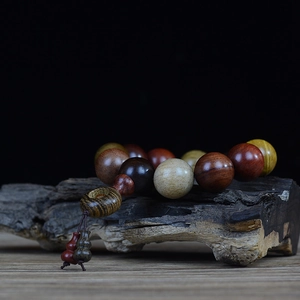 Detailed texture of multi-color redwood Buddhist beads on a dark vintage wooden background