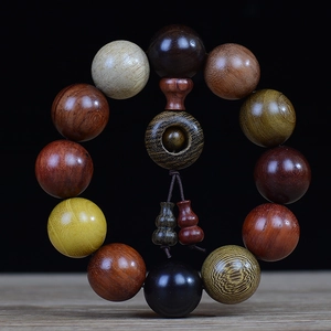 Macro shot of multi-colored wooden prayer beads with natural textures on a light wood surface