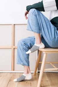 Close-up of white striped cotton short socks for men worn with blue denim jeans