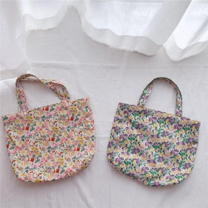 Detailed view of floral cotton tote bags with colorful flower patterns and handles