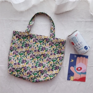 Close-up of floral canvas tote bag featuring purple flower patterns on white cotton