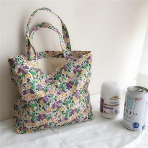 Detail of floral canvas tote bag with purple and yellow flower patterns on white fabric
