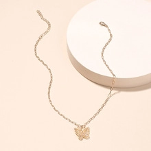 Close-up of gold butterfly pendant necklace with adjustable chain on white display