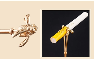 Macro shot of golden bee cigarette ring holder with smoking scene demonstration