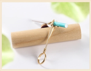 Detail of bee cigarette holder ring in matte gold finish holding a cigarette