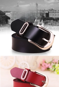 Detail view of black and red leather belts with rose gold buckles and oval metal accents