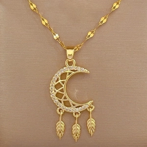 Close-up of golden moon dreamcatcher necklace with sparkling stones and feather charms