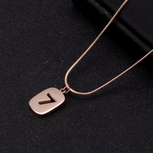 Macro view of rose gold snake chain necklace featuring a minimalist number 7 hollow pendant