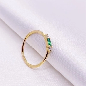 Elegant gold S925 silver ring with marquise green zircon on white silk background