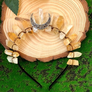 Macro detail of natural citrine crystal crown with metal moon on wood and moss base