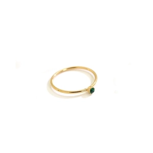 Minimalist gold titanium steel ring with a round green gemstone on white background