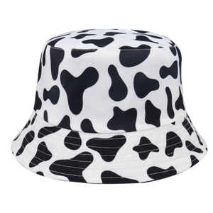 Détail d'un bob réversible avec motif de vache noir et blanc et coutures de bord renforcées