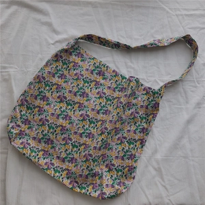 Detailed flat lay of purple floral cotton tote bag with long shoulder strap detail