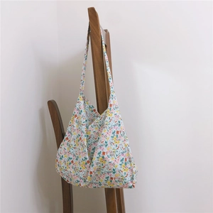 Detailed texture of a floral cotton tote bag hanging on a vintage wooden chair